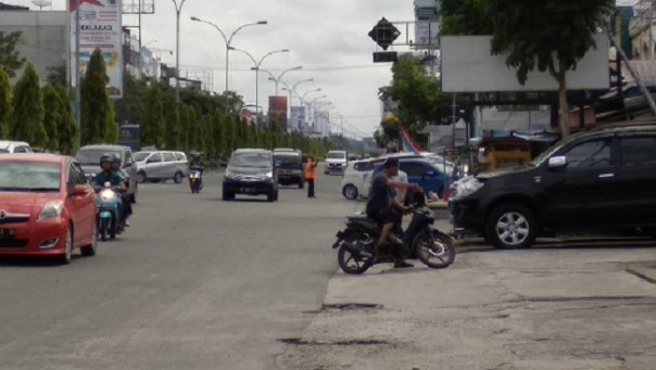 Seorang pengendara motor yang tidak mengenakan helm, memutar arah kendaraannya meski harus berlawanan arah. Aksi itu ia lakukan setelah melihat petugas menggelar razia di Jalan Tuanku Tambusai Pekanbaru. Foto: riandi 