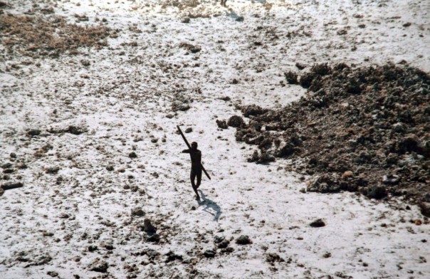 Seorang pria dari suku Sentinelese mengarahkan busur dan anak panahnya ke sebuah helikopter Indian Coast Guard saat terbang melintasi Pulau Sentinel Utara di Kepulauan Andaman