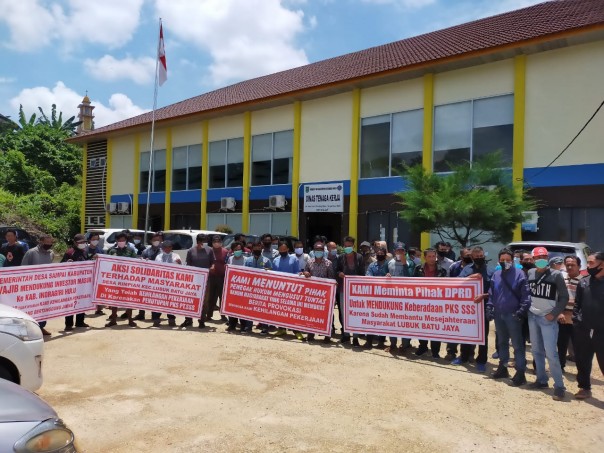 Karyawan PKS PT SSS mengadukan nasibnya ke kantor Disnaker Inhu dengan membentangkan spanduk bertuliskan bermacam aduan dan keluhan, Senin 8 Maret 2021/yuzwa